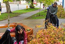 SPU's new freshman picking up leaves at a City Quest event.